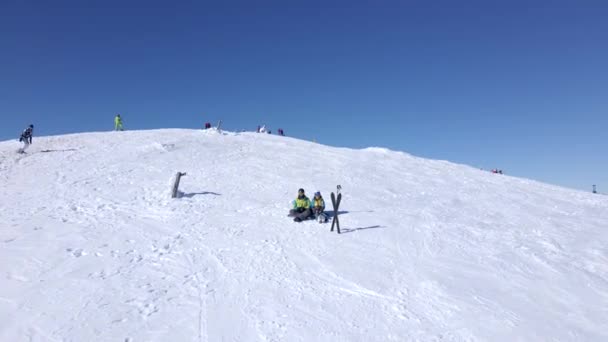 Flygfoto över människor skidåkare och snowboardåkare på toppen av berget — Stockvideo