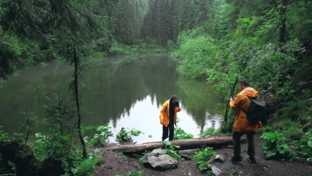 Senderistas tomando fotos en el teléfono ta montañas lago en el bosque — Vídeos de Stock