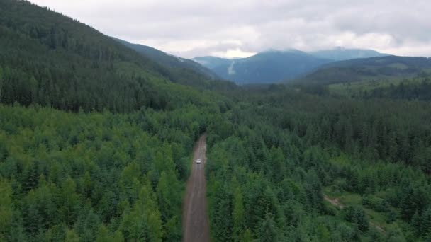 Luftaufnahme eines Geländewagens, der sich auf einer Straße im Gebirge bewegt, bewölkt und regnerisch — Stockvideo