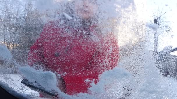 Man cleaning car windshield of ice — Stock Video