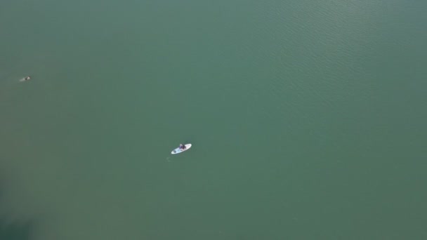 Vista aérea de pessoas em pranchas de jantar no lago com água azul — Vídeo de Stock