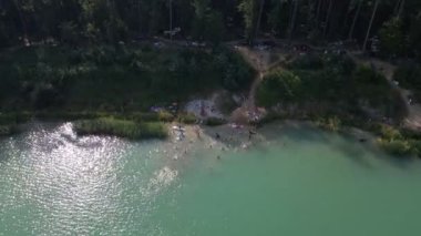 Yemek tahtalarında yüzen, güneşlenen insanların hava görüntüsü. yaz gölü aktiviteleri