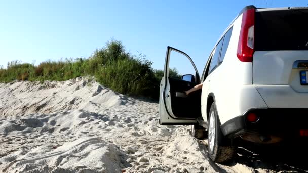 Kobieta wychodzi z samochodu w płetwach na piaszczystej plaży — Wideo stockowe