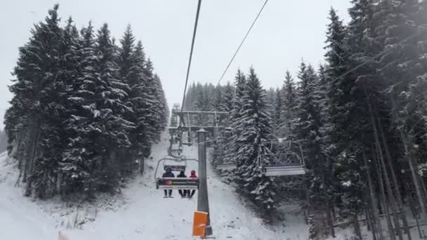 Bukovel, Ucrania: 13 de enero de 2021: telesilla subiendo por una colina nevada — Vídeos de Stock