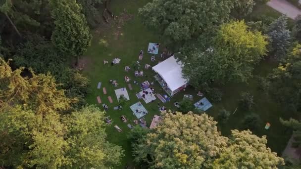 Люди лежать на землі в громадському парку слухаючи музику — стокове відео