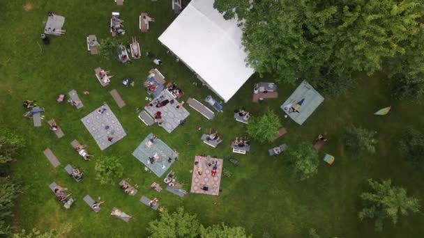 Pessoas deitadas no chão no parque público ouvindo música — Vídeo de Stock