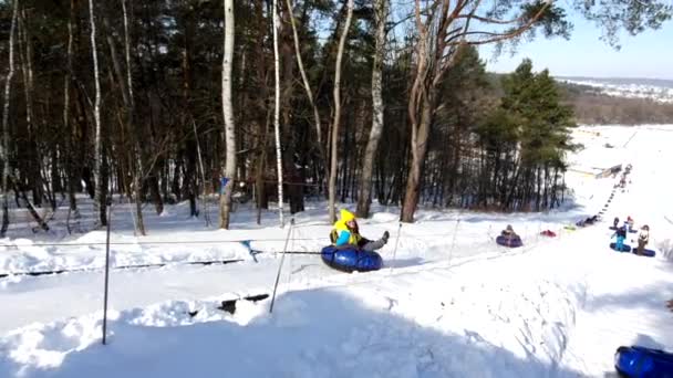 Счастливая женщина на тюбинге для подъема снега — стоковое видео