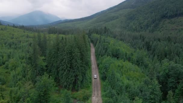 Antenn utsikt över SUV bil rör sig längs vägen i berg mulet regnigt väder — Stockvideo