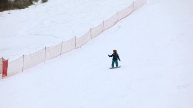 Meydan, Ukrayna - 20 Şubat 2021: küçük çocuk snowboard yapmayı öğreniyor