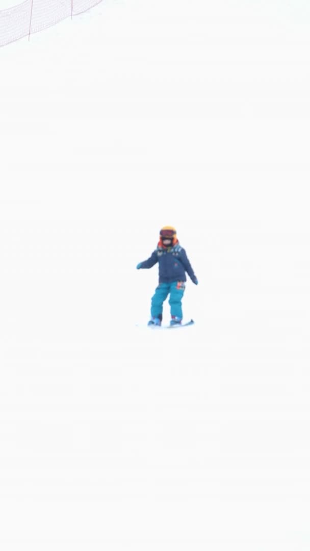 Majdan, Ukraina - 20 lutego 2021: mały chłopiec uczy się jeździć na snowboardzie — Wideo stockowe