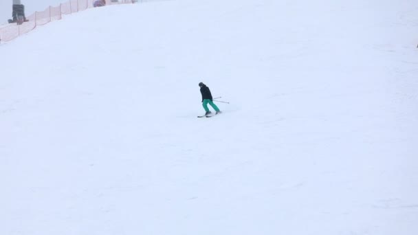 Mensen skiën en snowboarden stoeltjeslift op achtergrond — Stockvideo