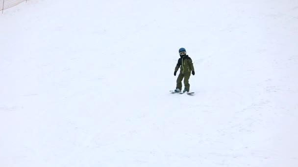 Maidan, Oekraïne - 20 februari 2021: kleine jongen leert snowboarden — Stockvideo