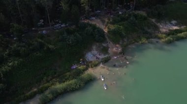 Yemek tahtalarında yüzen, güneşlenen insanların hava görüntüsü. yaz gölü aktiviteleri