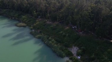 Göl kıyısında dinlenen insanların hava görüntüsü.