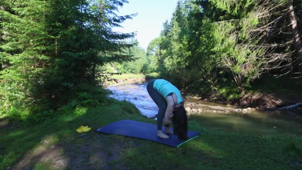 Vrouw doen yoga op bergen rivier strand — Stockvideo