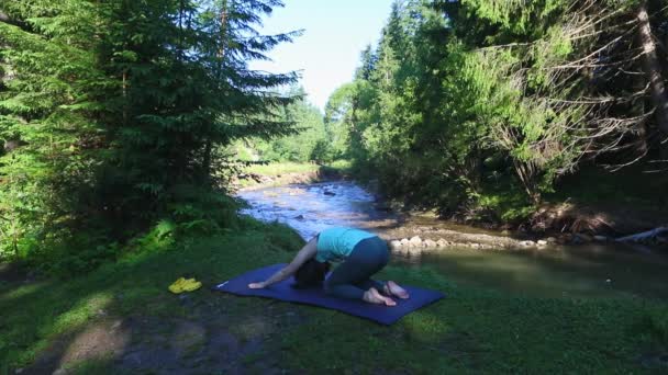 Frau macht Yoga am Strand des Flusses Berge — Stockvideo