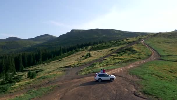 Casal viajante no carro suv apreciando vista das montanhas dos Cárpatos — Vídeo de Stock