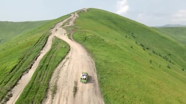 Letecký pohled SUV vozidlo jede po kopci na vrchol hory — Stock video