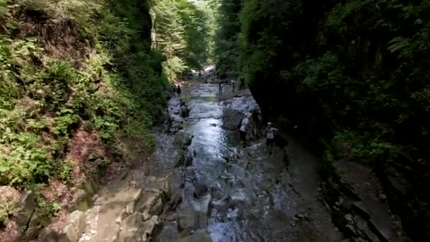 Manyava, Oekraïne - 31 juli 2021: mensen die per canyon naar de waterval lopen — Stockvideo