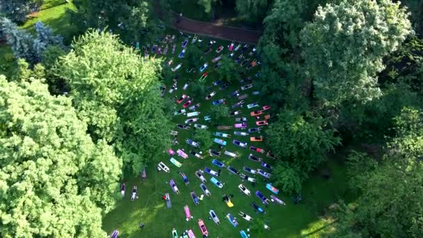 Människor gör yoga i stadens offentliga park — Stockvideo