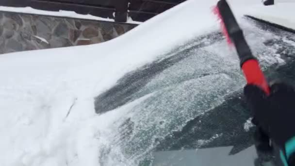 Coche limpio de nieve en las nevadas — Vídeo de stock