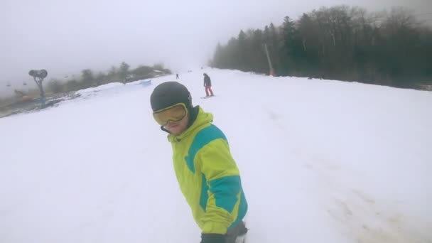 Bukovyrsia, Ucrania - 19 de diciembre de 2020: hombre girando sobre tabla de snowboard en la ladera — Vídeos de Stock