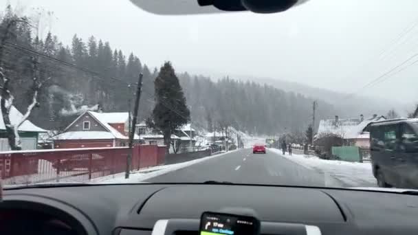 Bukovel, Ukraina - 13 januari 2021: åkning på bil med snöad väg — Stockvideo