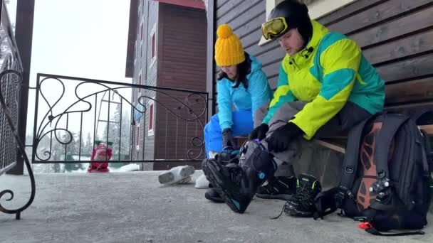 Dragobrat, Ukraina - 13 Januari 2021: pasangan mengenakan sepatu ski dan sepatu bot snowboarding — Stok Video