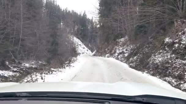 Auto durch verschneite Bergstraße gefahren — Stockvideo