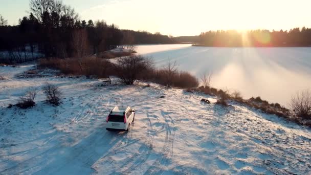 Aerial view of a suv car stopping at lake beach with frozen water — Stock Video