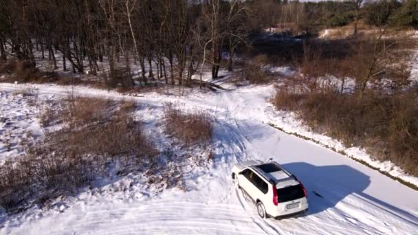 Antenn utsikt över SUV bil rör sig med snötäckta fält — Stockvideo