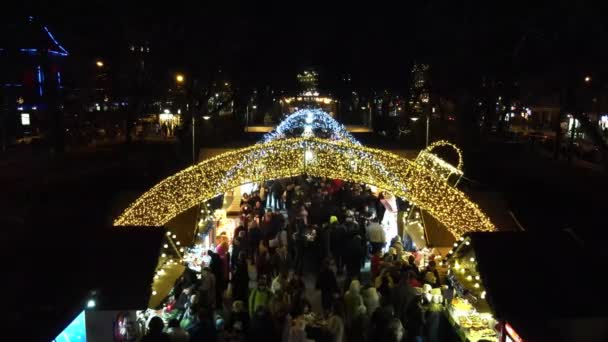 Lviv, Ucrania - 4 de enero de 2021: personas caminando por la feria de Navidad por la noche — Vídeo de stock