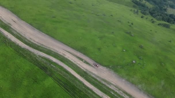 Luftaufnahme Geländewagen, die von einem Hügel auf die Spitze des Berges fahren — Stockvideo
