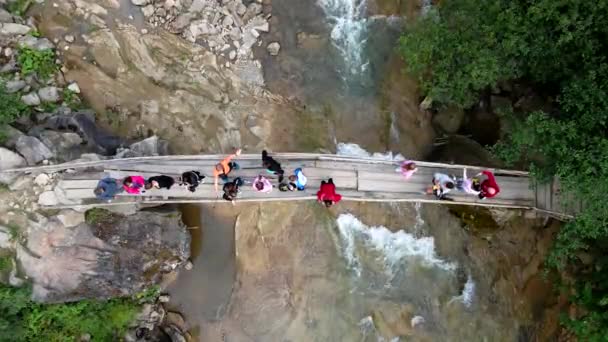 Luftaufnahme von Menschen an der Brücke über den Gebirgsfluss — Stockvideo