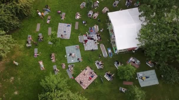 Människor som ligger på marken i offentlig park lyssna musik — Stockvideo
