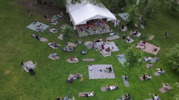 Lviv, Ucrania - 19 de julio de 2021: personas tumbadas en el suelo en el parque público escuchando música — Vídeos de Stock