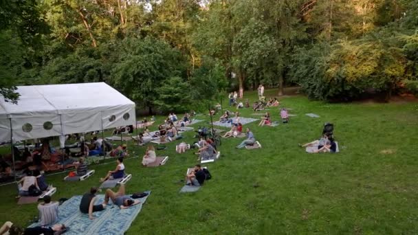 Lviv, Ucrânia - 19 de julho de 2021: pessoas deitadas no chão no parque público ouvindo música — Vídeo de Stock