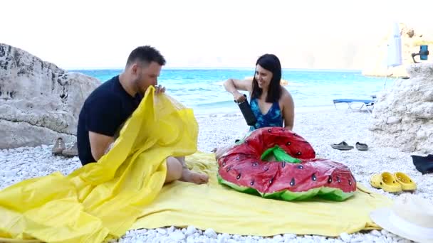 Pareja que se divierte inflar colchón inflable en la playa del mar — Vídeo de stock