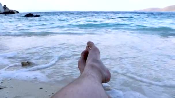 Ponto de vista homem pernas deitado na praia mar ondas no fundo — Vídeo de Stock
