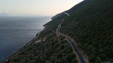 Araba yolculuğu konsepti. Soldaki adada deniz kenarındaki dağ yolunun havadan görünüşü.