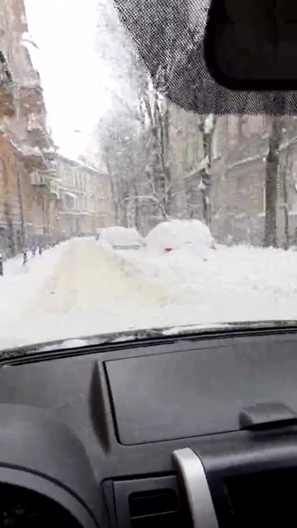Прокат машин на снежной улице города — стоковое видео