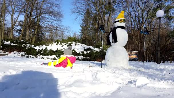 2021年2月10日，乌克兰利沃夫：雪人附近可爱的幼儿在雪地里破晓 — 图库视频影像