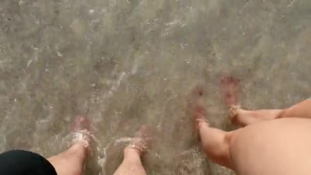 Punto di vista uomo e donna piedi in spiaggia bagnati dalle onde del mare — Video Stock