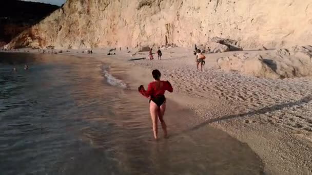 Câmera girando em torno de dança menina no mar praia no por do sol — Vídeo de Stock
