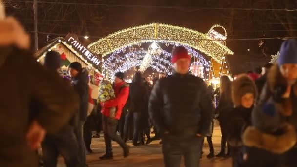 Lwów, Ukraina, 20 grudnia 2020 r.: ludzie przechodzący przez plac miejski na jarmarku bożonarodzeniowym. — Wideo stockowe