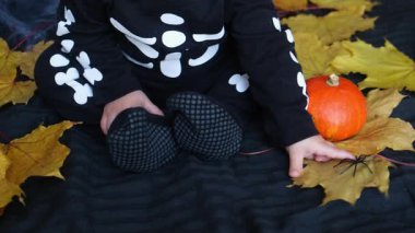 Baby in Skeleton Costume with Halloween Decor.