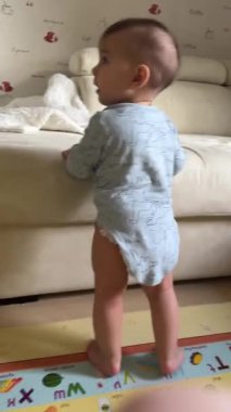 Bebek Onesie 'de Ayakta ve Dans Ediyor