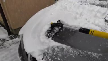 Kışın araba aynasından karı kazımak.