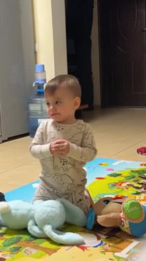 Bebekler renkli bir oyun odasında dizlerinin üzerinde oynuyorlar.