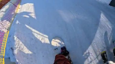 Bir snowboardcunun karlı yamaçta süzülürken pov çekimi.